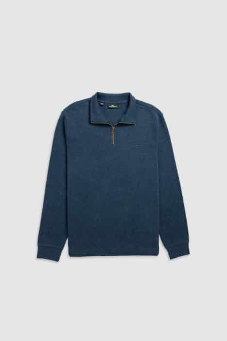 A blue long-sleeve quarter-zip jumper with a stand collar, small logo on the left chest, and ribbed cuffs, laid flat on a light grey background.