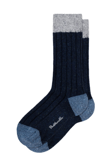 A pair of ribbed socks with dark blue bodies, grey cuffs, and light blue heels and toes. The brand name, Pantherella, is embroidered in white on the sole.