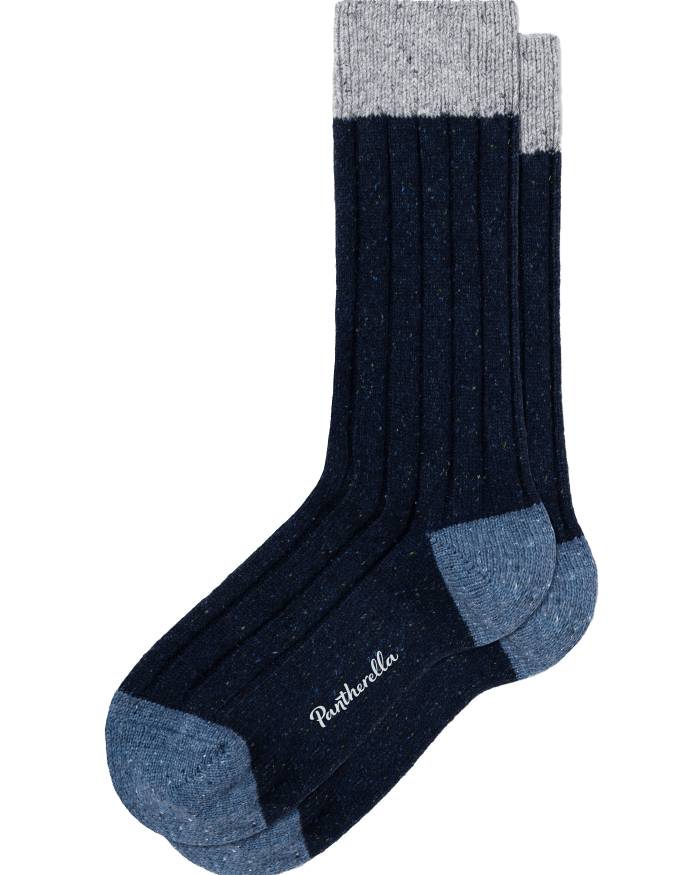A pair of ribbed socks with dark blue bodies, grey cuffs, and light blue heels and toes. The brand name, Pantherella, is embroidered in white on the sole.
