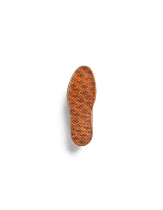 The image shows the sole of a shoe with an orange and black textured pattern, viewed from above on a white background.