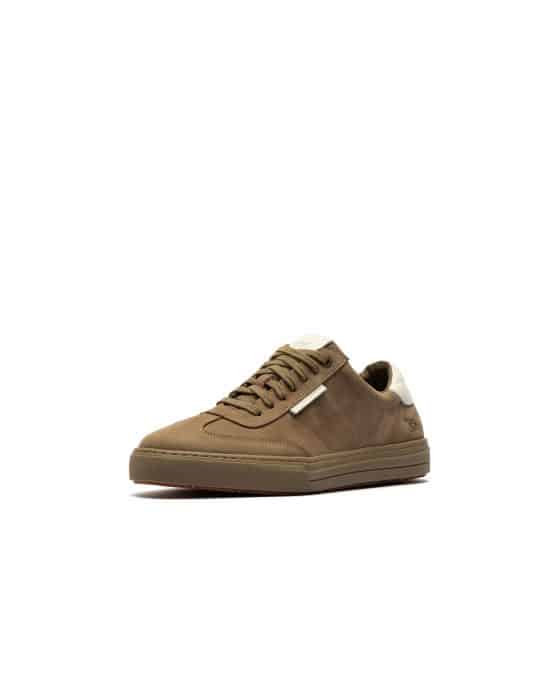 Brown low-top trainer with beige accents, white tongue, and lace-up fastening, displayed on a white background. The shoe is positioned at an angle showing the side and front.