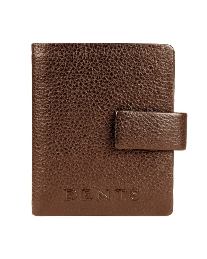 Brown leather passport holder with a press-stud fastening and the Dents logo embossed at the bottom.