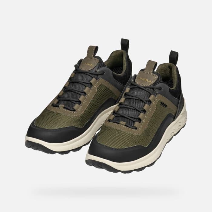 Pair of olive green and black trainers with white midsoles and black laces.
