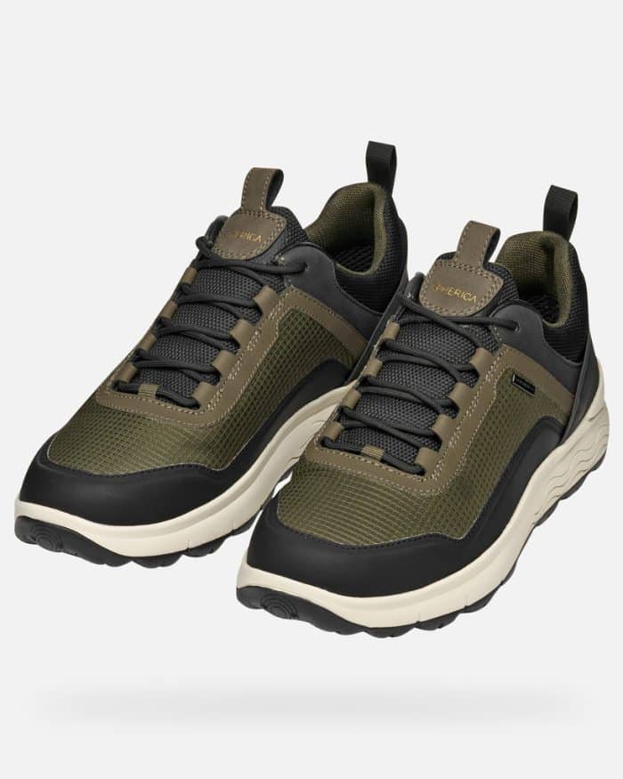 Pair of olive green and black trainers with white midsoles and black laces.