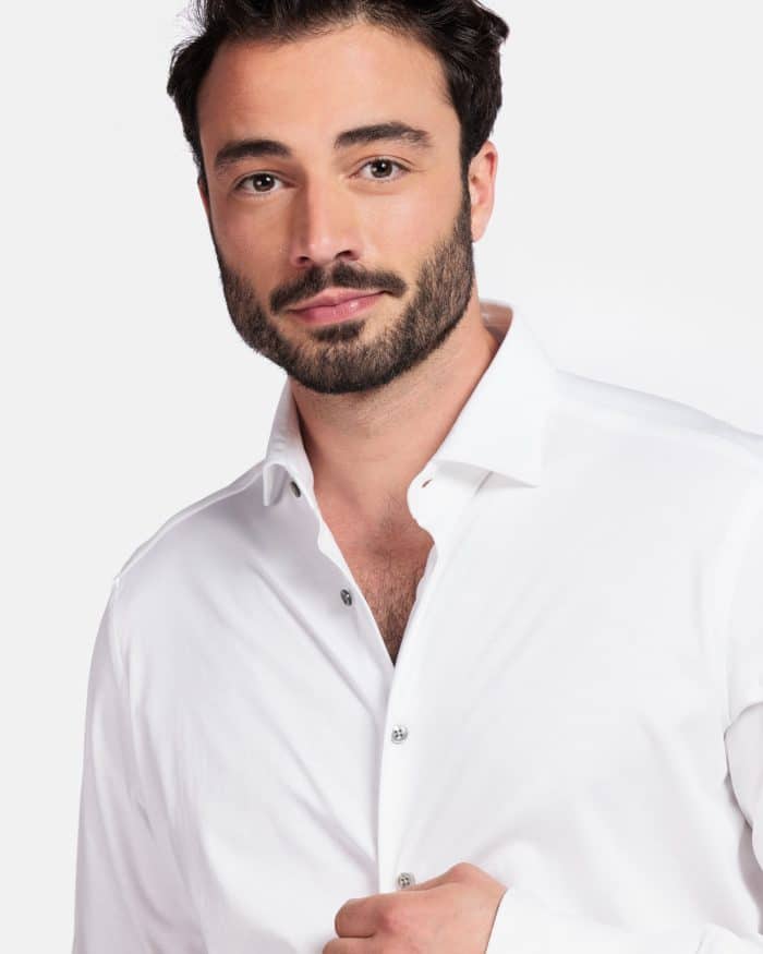 A man with a beard wearing a white button-down shirt.