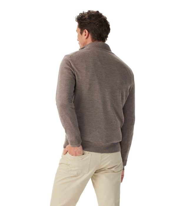 A person from behind wearing a brown quarter-zip jumper and beige trousers, with a hand in their back pocket.