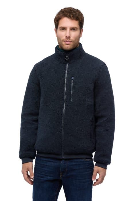 A man wearing a navy blue zip-up fleece jacket.